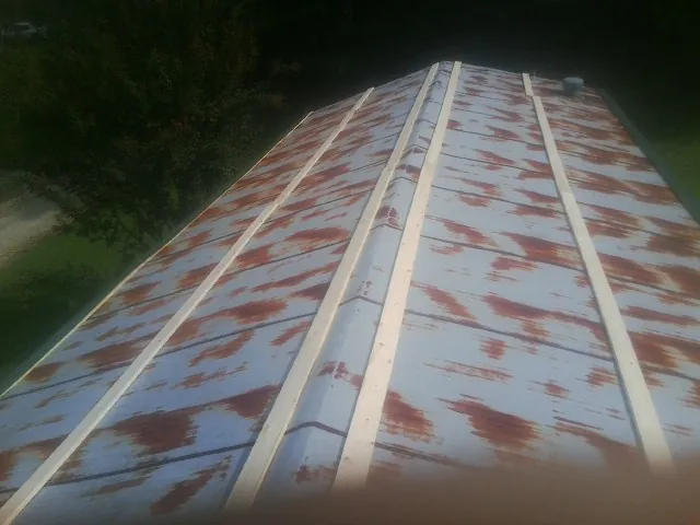 Rusted metal roof panels with new wood purlins before replacement — Storm Damage Roof Repair in Wenonah by Roofing Brothers